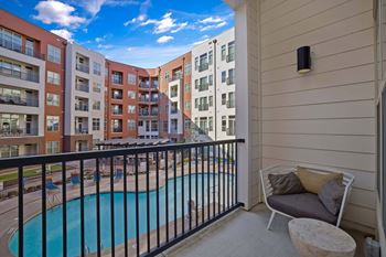 a balcony with a pool and an apartment building